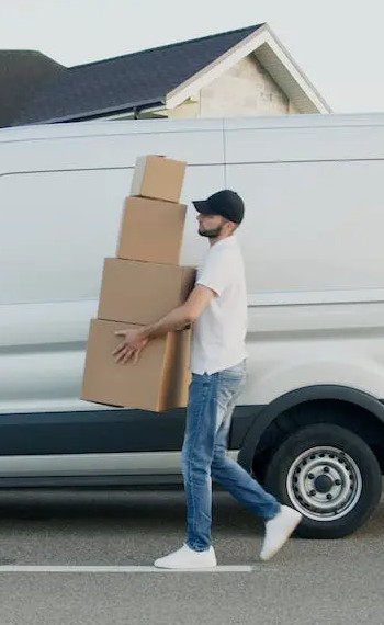 Iskusni radnik pri selidbi nosi kutije prije kombi prijevoza u Splitu