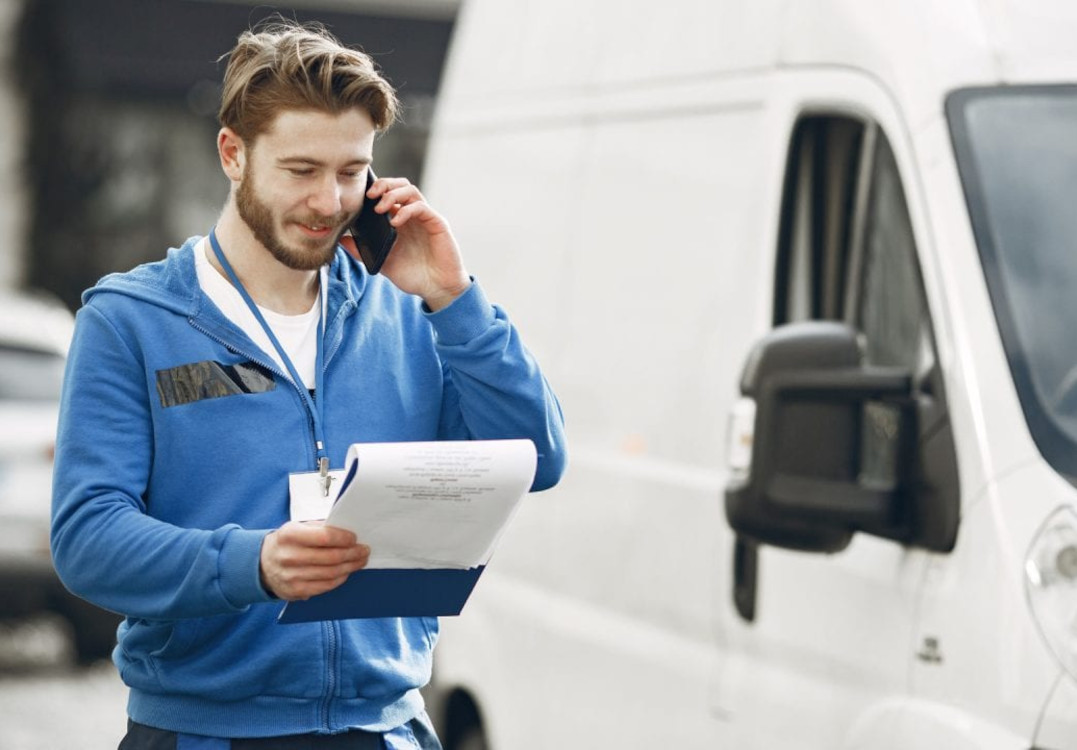 Vozač s dokumentima i telefonom ispred bijelog kombija dogovara selidbu u Splitu